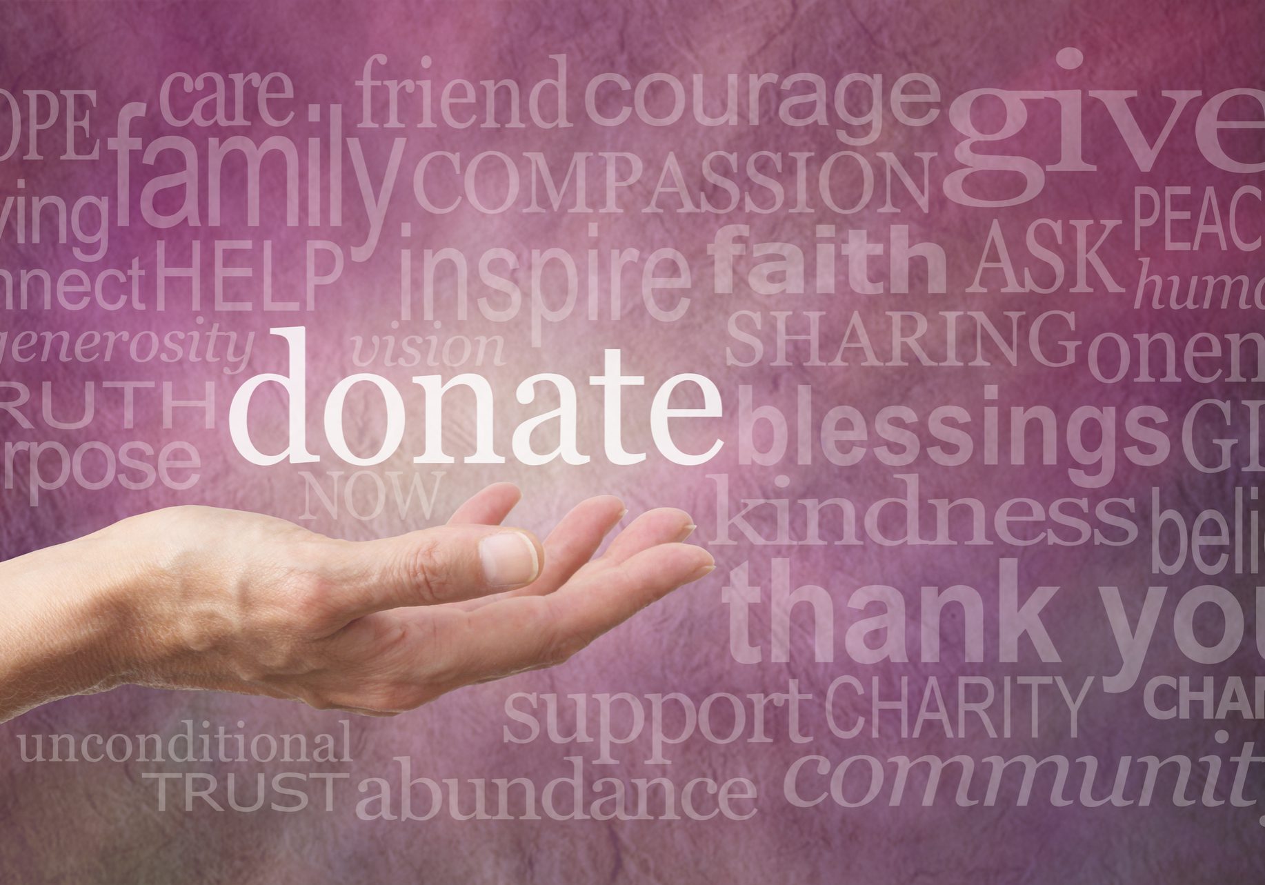Female hand outstretched with palm side up and a white 'donate' word floating above surrounded by different sized words related to charity on a purple stone effect background